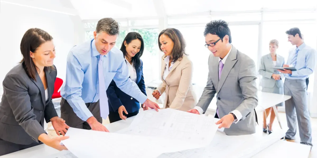 Team meeting around plans and documents.